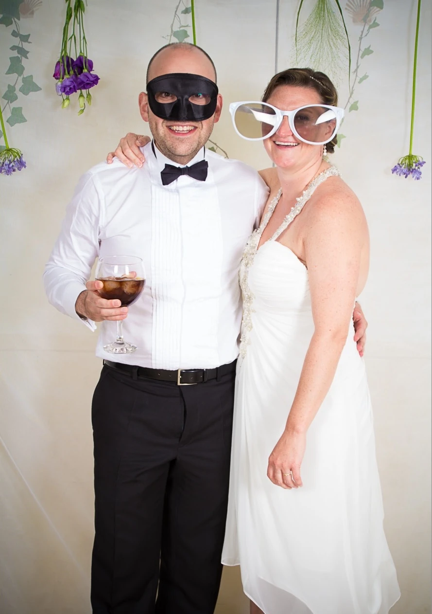 The couple with playful glasses at their wedding